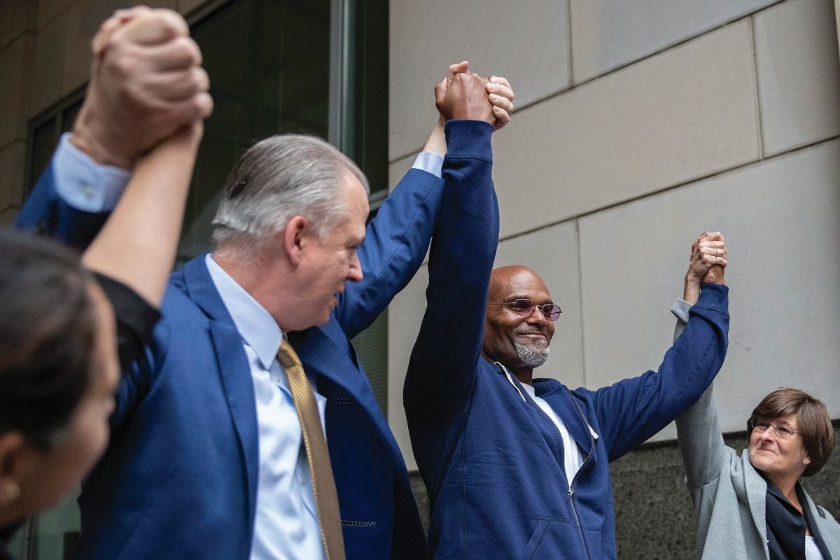 Willie Veasy, second from right, raises his arms in victory along with his team of lawyers, Nilam Sanghvi, far left, Jim Figorski and Marissa Bluestine, right, after he exited the Center for Criminal Justice as a free man for the first time in 27 years following his exoneration, Wednesday, Oct. 9, 2019 in Philadelphia.  (Heather Khalifa/The Philadelphia Inquirer via AP)